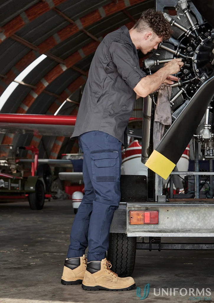 Man repairing airplane engine in Syzmik men’s rugged cooling long shirt for hot days