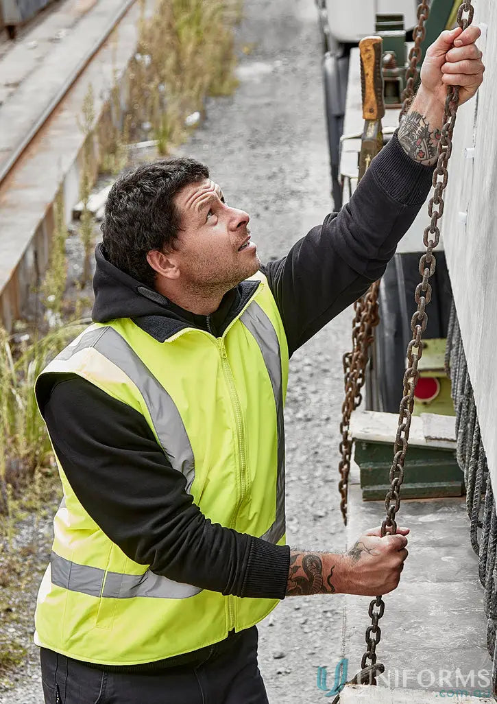 Man in black shirt wearing high visibility waterproof reversible vest with reflective strips