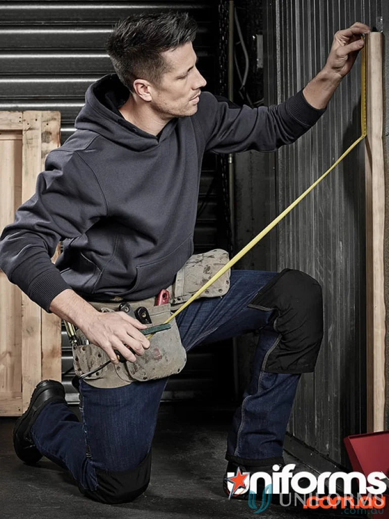 Man in work clothes measuring wood wearing syzmik impact protection unisex knee pads