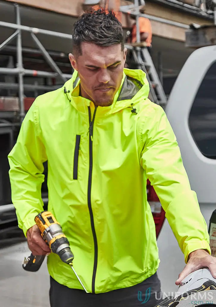 Man in neon yellow hoodie holding drill in unisex super light rain packable rain jacket zj260
