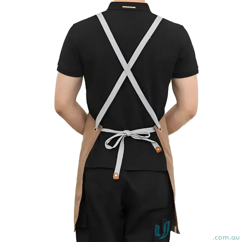 Person wearing brown waterproof canvas kitchen apron with gray straps and tied waist