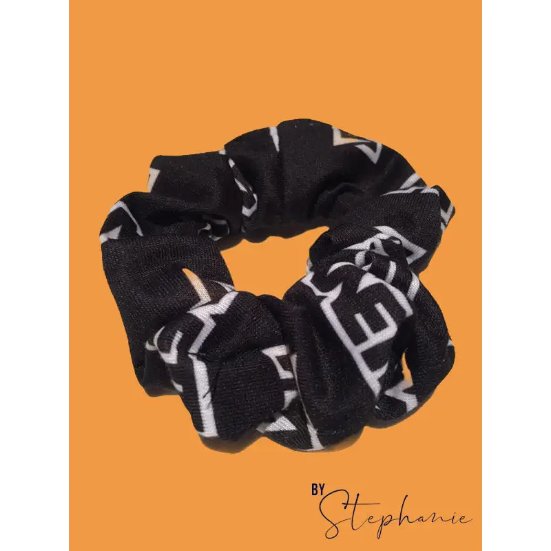 White scrunchie made of black fabric with bold white geometric lettering perfect for uniforms and workwear looks sharp