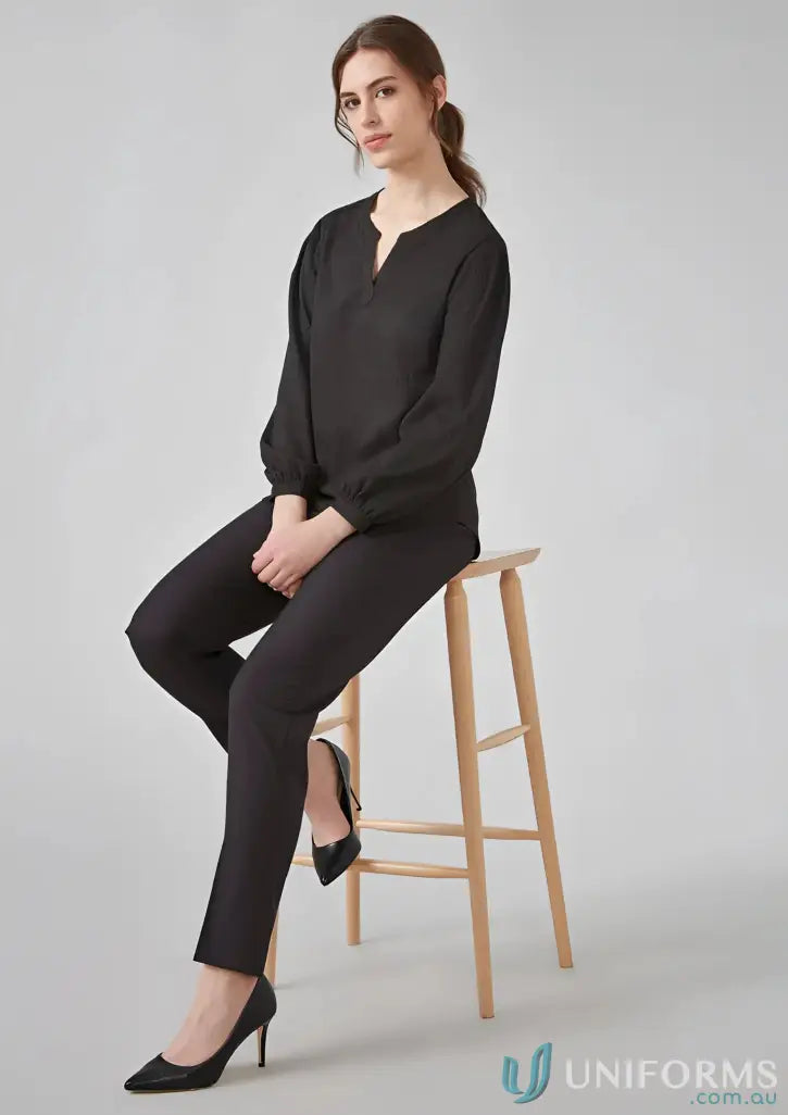 Woman in black long sleeve blouse and pants sitting on a wooden stool for Womens Ruche Long Sleeve Blouse