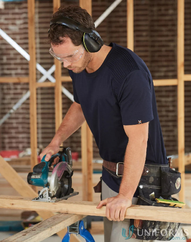 Man in safety gear using a circular saw wearing XStreet TrueDry Tee with unique shoulder panel