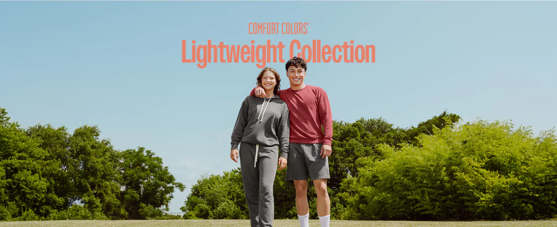 Two people in athletic wear showcasing Gildan promotional apparel and merchandise