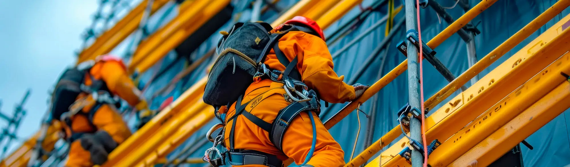 Construction workers climbing scaffolding with PPE height safety gear for safe work