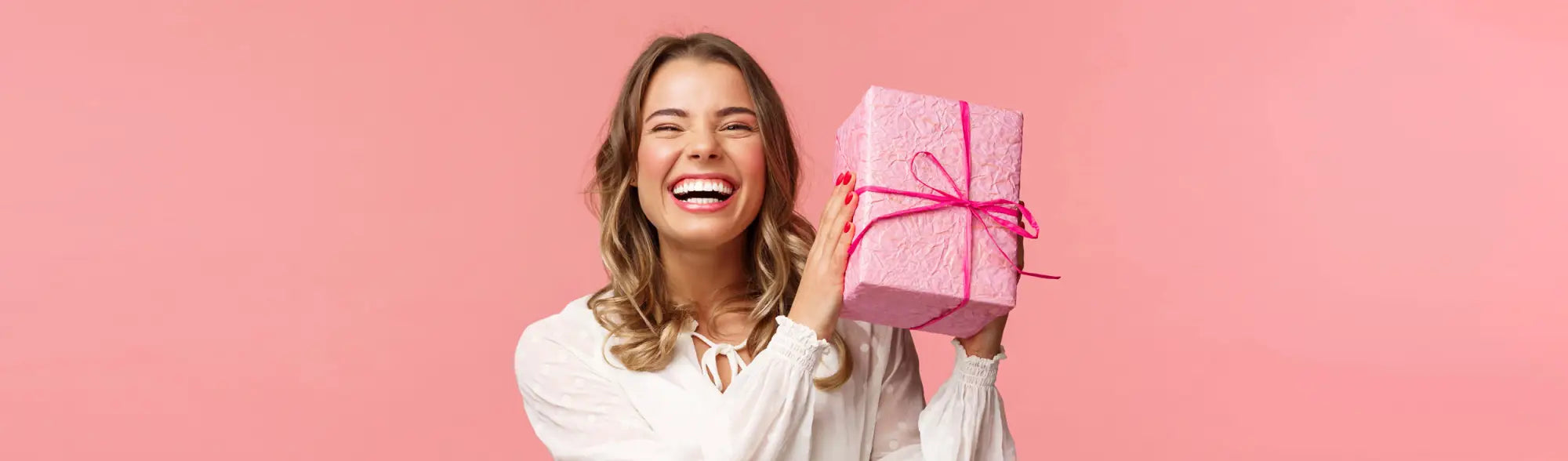 Laughing woman holding pink gift for Rewards Program, perfect for loyalty rewards fans