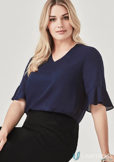 Woman wearing navy blouse from Aria Fluted collection, stylish fluted sleeve workwear