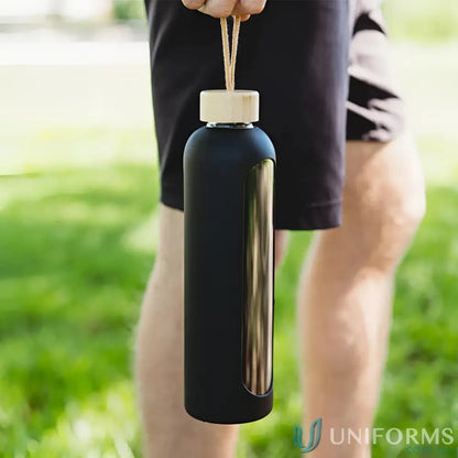 Sleek black borosilicate glass water bottle with wooden cap and silicone sleeve