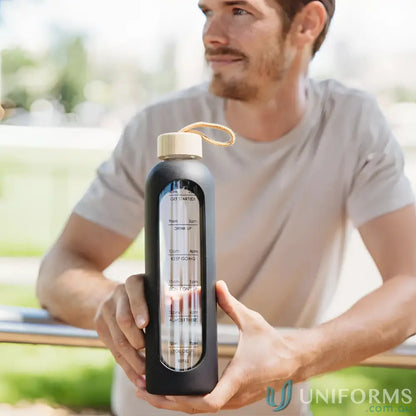 Black borosilicate glass water bottle with time markings and silicone sleeve