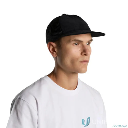 Man wearing black trucker hat with flat peak made from cotton 16-wale partridge cord