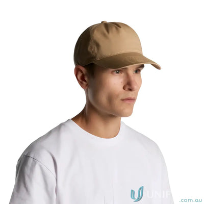 Man wearing a tan AS Colour Frame Soft Cap 1164 with curved peak and plastic snapback