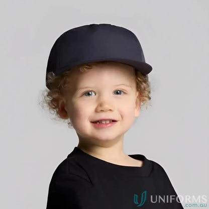 Cute toddler with curly blonde hair wearing AS Colour Kids Surf Cap with foam peak
