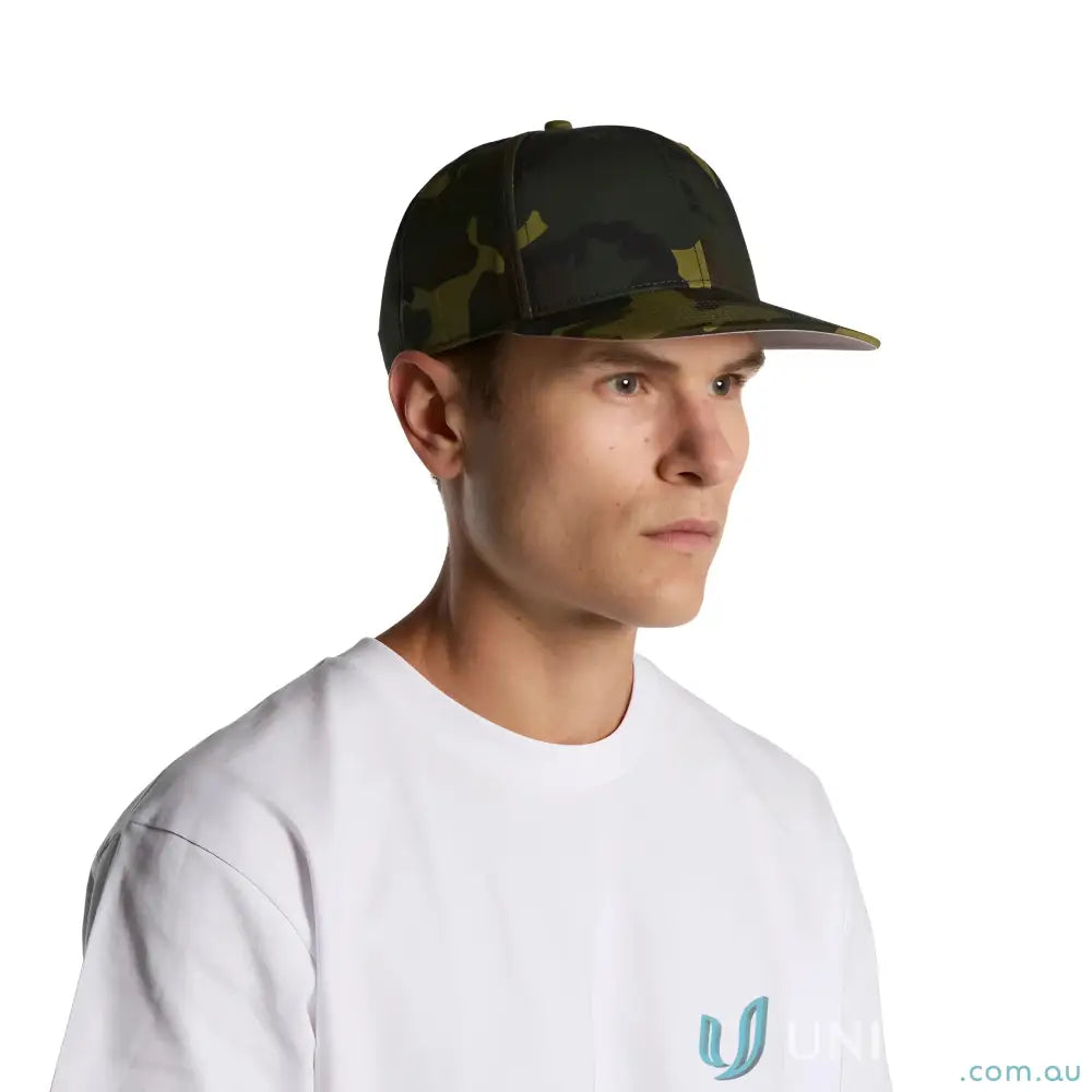 Man wearing AS Colour Stock Camo Cap 1183 with flat peak and dark green camo pattern