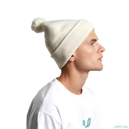 Cream-colored knit beanie with a pom pom made from recycled acrylic material