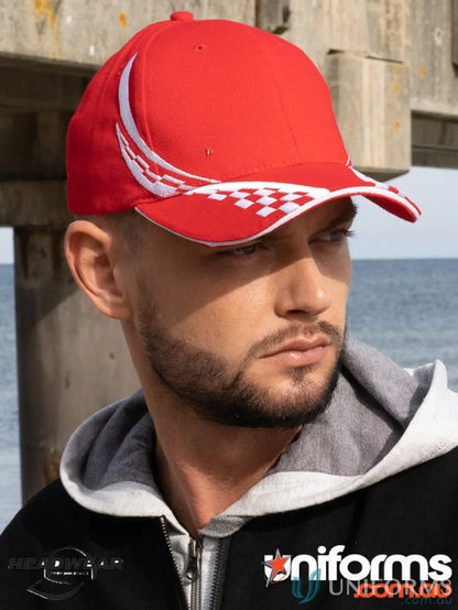 Man in black workwear with swirling checks and red baseball cap with white accents