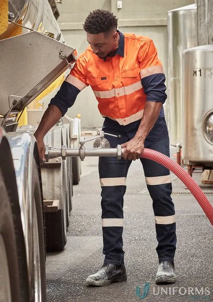 Man in Bio Motion Taped stretch workwear jeans operating a hose outdoors