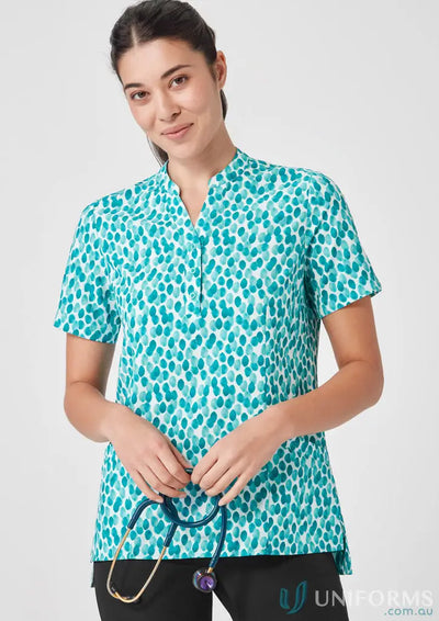 Woman wearing Bizcare Women’s Florence Stardust Print Tunic with patterned teal scrub top