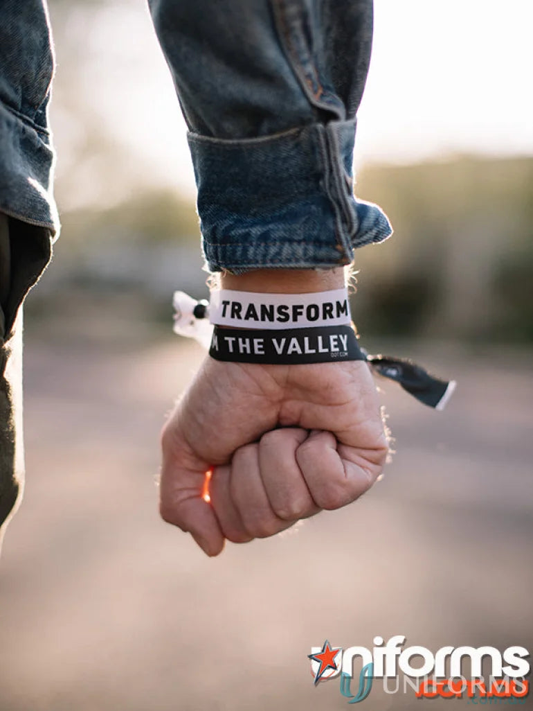 Wrist with two branded silicone wristbands showcasing free decoration options and pad print