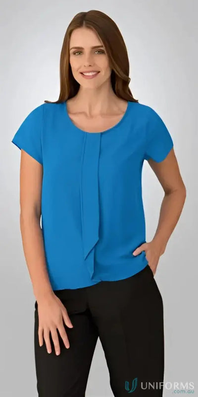 Woman in blue woven Cascade Top blouse and black pants, perfect for uniforms