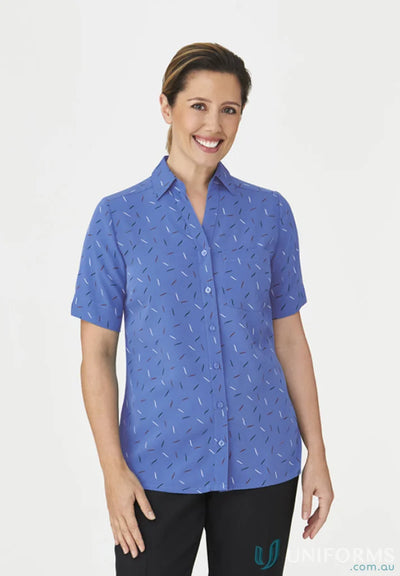Woman in royal blue City Stretch Spot Tunic with subtle pattern and black pants