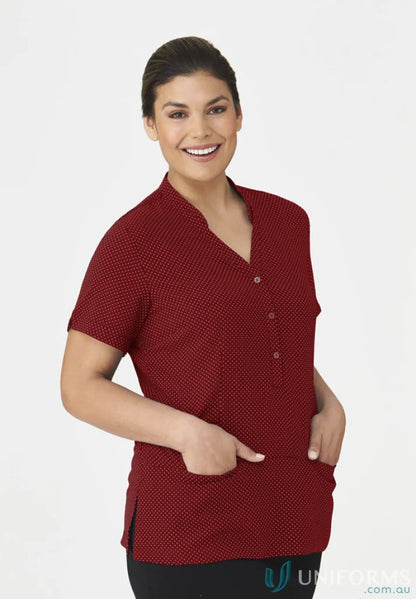 Smiling woman in City Collection spot tunic top with polka dots and black workwear pants