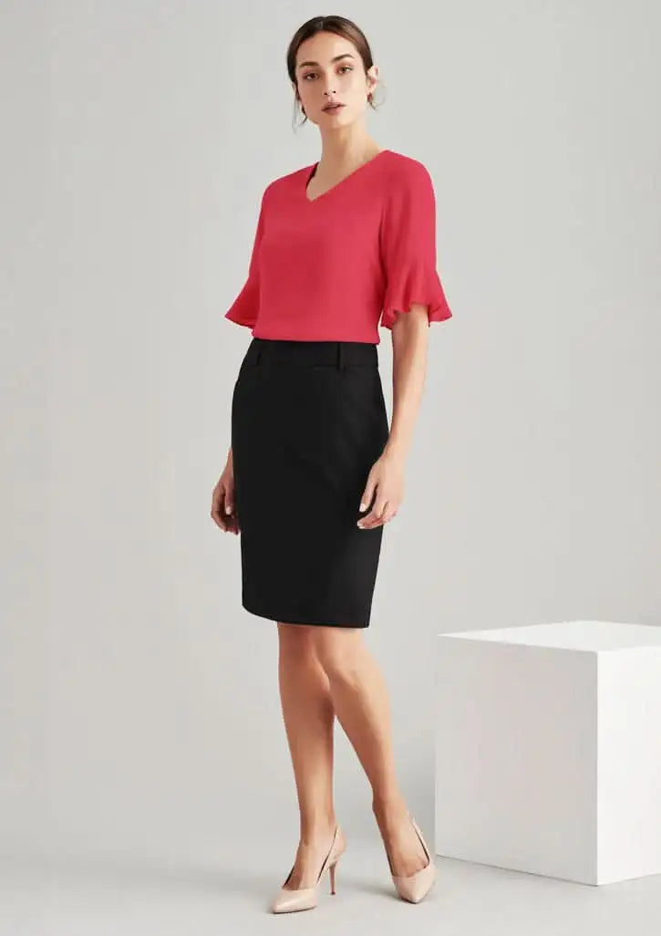 Woman in red top and black wool multi pleat skirt showing comfort wool stretch style
