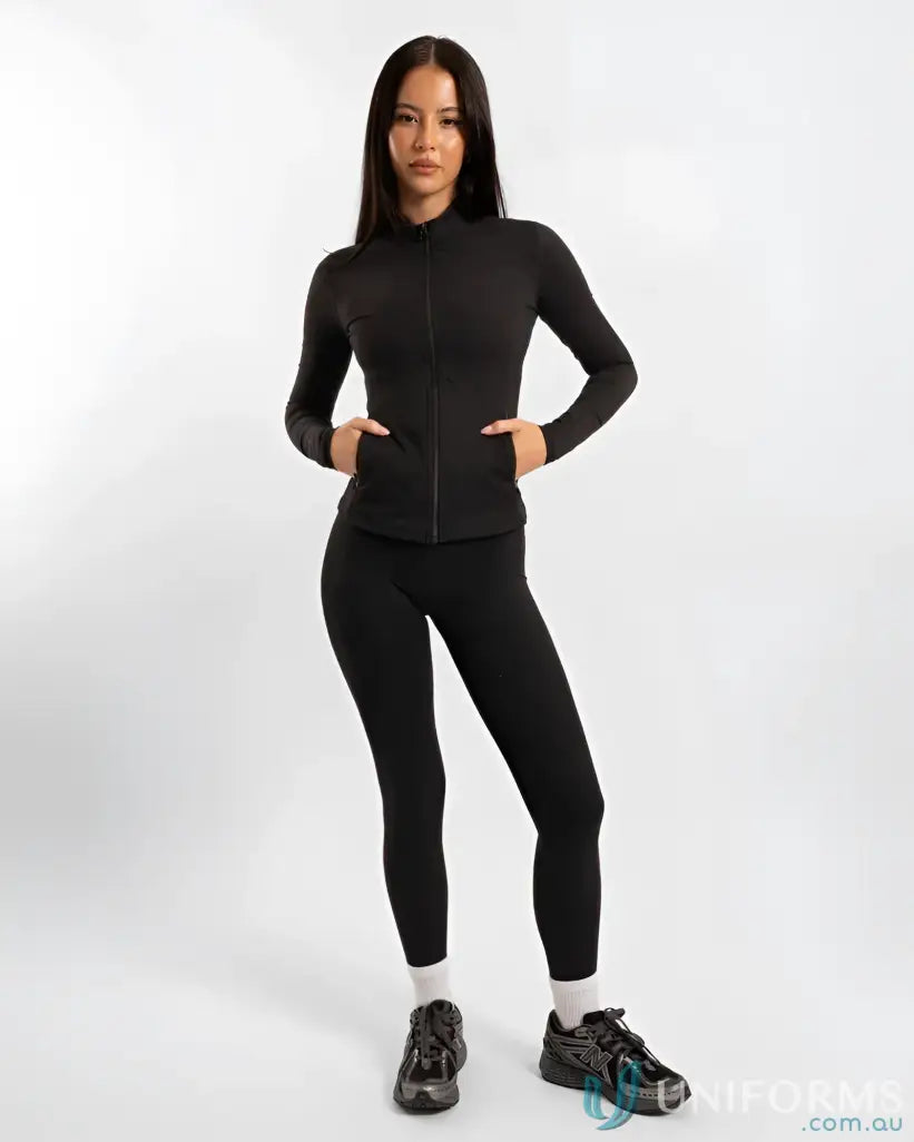 Woman in black athletic wear showing off the Contour Zip Jacket with high neck collar