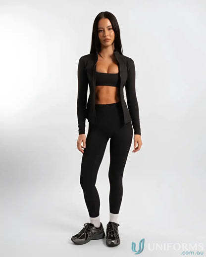 Woman in black athletic wear showcasing the Contour Zip Jacket with high neck collar