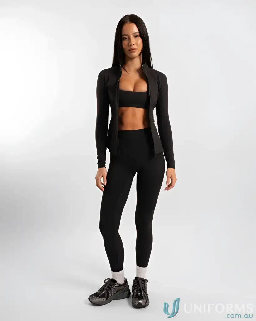 Woman in black athletic wear showcasing the Contour Zip Jacket with high neck collar