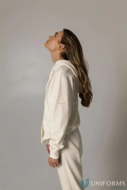 Woman in a cream-colored Hudson Oversized Cotton Hoodie, a stylish garment dyed hoodie perfect for uniforms