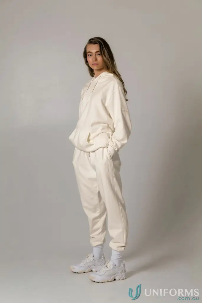 Woman in a cream-colored Hudson Oversized Cotton Hoodie, perfect for uniforms or casual wear