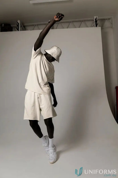 Man in matching beige Tommy Trackshorts jumping, perfect for uniforms or casual workwear