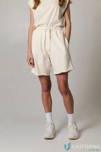 Woman in Tommy Trackshort PFD matching cream-colored top and shorts workwear uniform