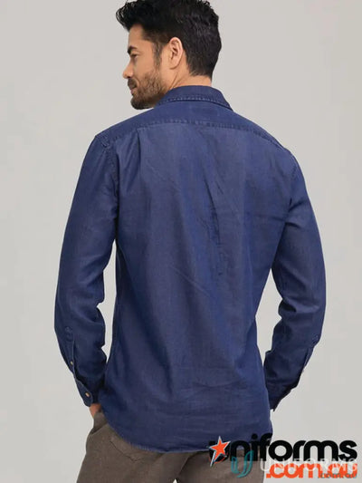 Man modeling a denim shirt with sports fit and garment washed look in brown pants