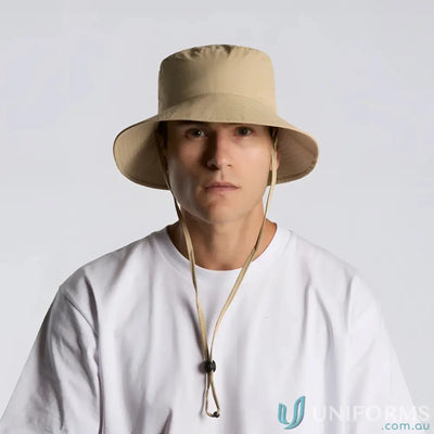 Beige wide brim bucket hat with chin strap and reinforced design for sun protection