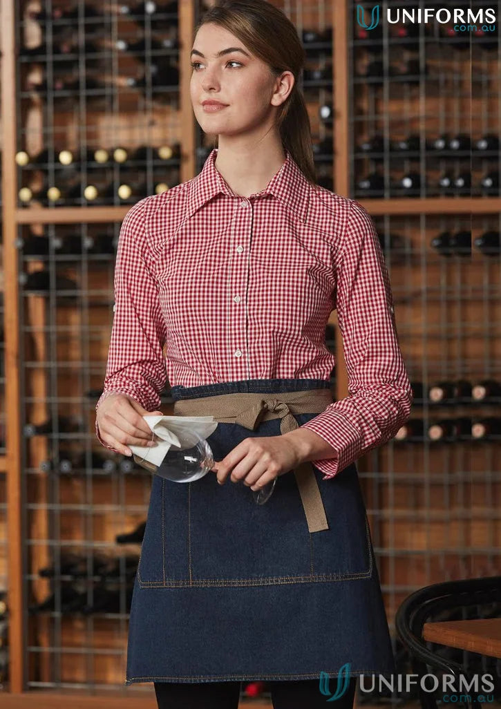 Woman in east village half denim apron holding wine glass and cloth, stylish and functional