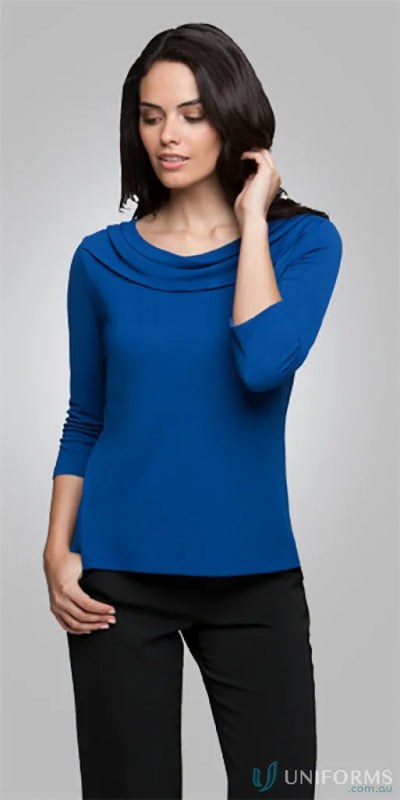 Eva Knit style woman in blue cowl neck top and black pants showcasing the Eva Knit 3Q Top