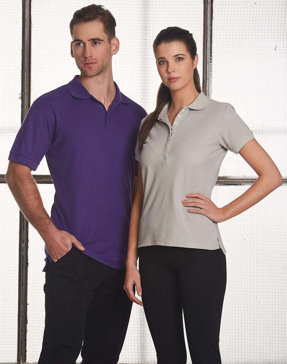 Man and woman in matching Heathmont TrueDry pique polo shirts, purple and gray