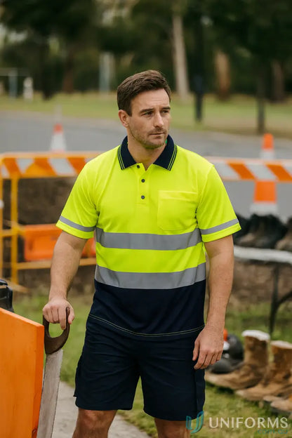 Man in HiVis SS Taped Polo with double stripe workwear holding a saw