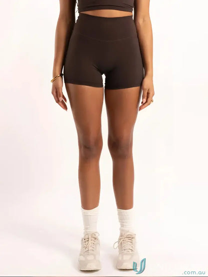Woman wearing Invicible Scrunch Chocolate Shorts, stylish workwear with invisible scrunch