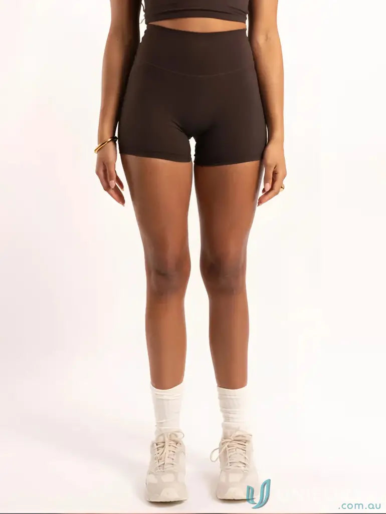 Woman wearing Invicible Scrunch Chocolate Shorts, stylish workwear with invisible scrunch