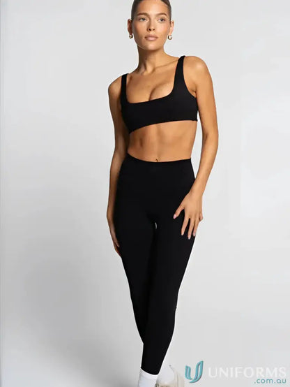 Woman in black sports bra and leggings wearing Invincible Scrunch Onyx Leggings, perfect for uniforms or workwear