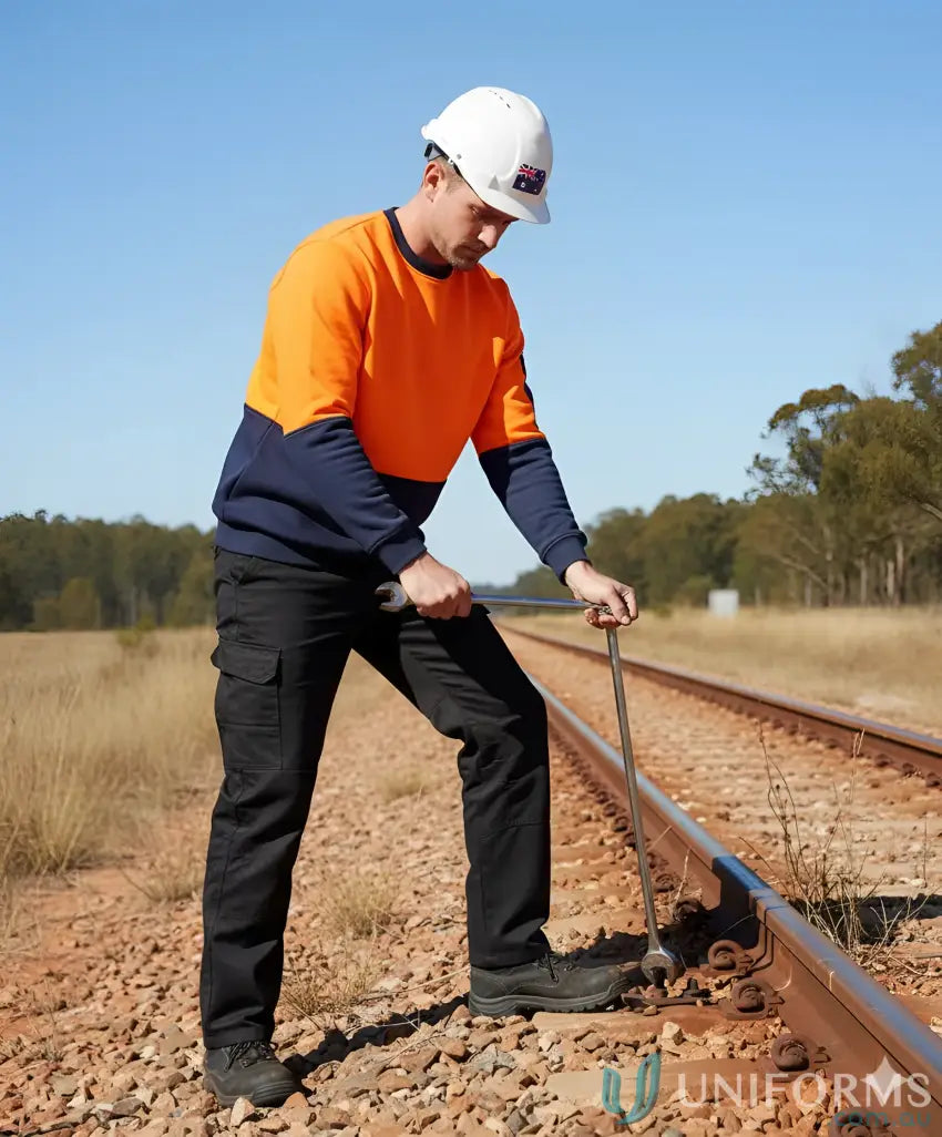 Man in work attire adjusting railroad tracks wearing JBs HiVis Fleecy Crew Neck Jumper