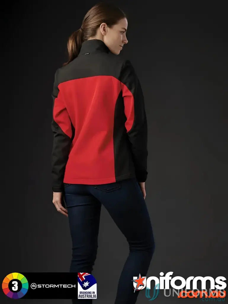 Woman wearing red and black women’s Cascades Softshell jacket with dark jeans for outdoor adventures