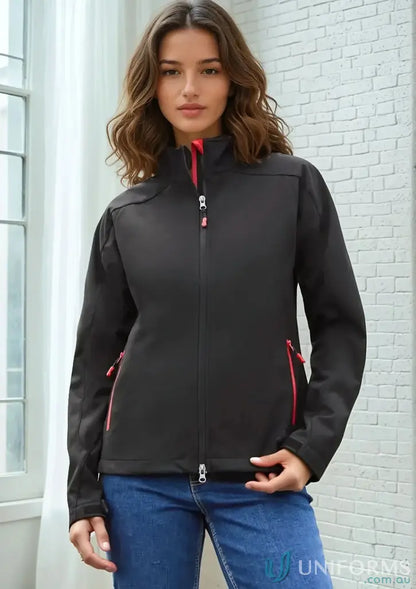 Lady wearing Ladies Geneva softshell jacket with red accents and blue jeans
