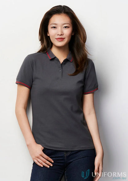Lady wearing dark grey short sleeve polo from Ladies Jet Collection with red trim
