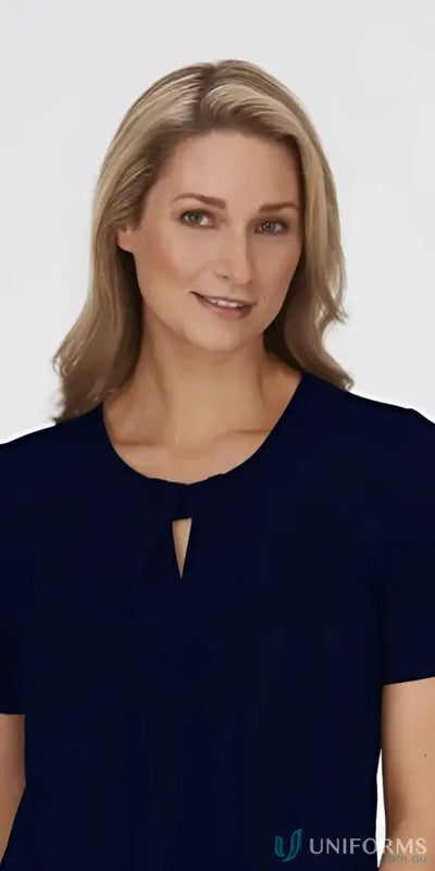 Blonde woman in navy blue keyhole knit top with crepe texture, perfect for uniforms