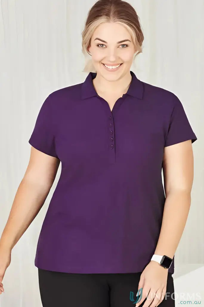 Smiling woman in dark purple Ladies Krue Polo for workwear game and ladies talon short