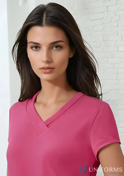 Fashionable pleat fold Lana Top with dark-haired woman in pink jersey knit V-neck shirt